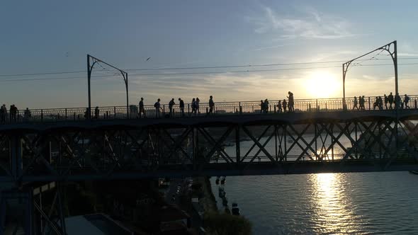 People Walking on The Bridge at Sunset alt