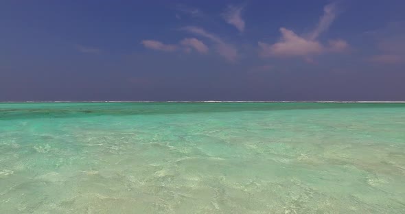 Natural above travel shot of a white sand paradise beach and blue water background in colourful 4K alt