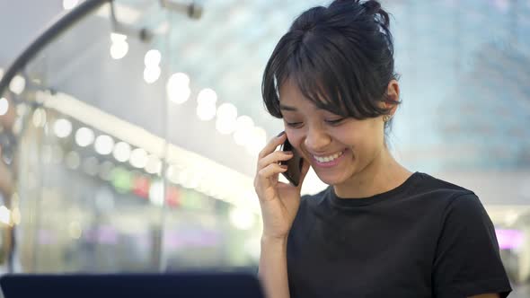 Portrait of Young Asian Female with Laptop Smiling Talking on Phone