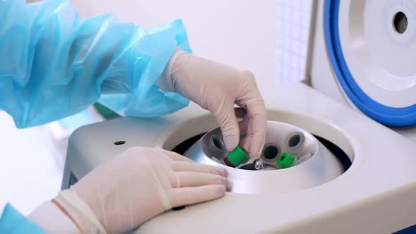 Picture of Nurse in Gloves Working in Clinic Putting Blood Tubes in Sterilization Machine and Switch alt