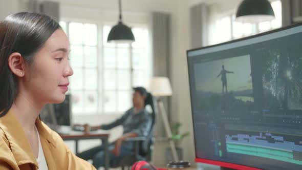 Female Video Editor Works With Footage And Sound On Computer. She Turns And Warmly Smiles alt