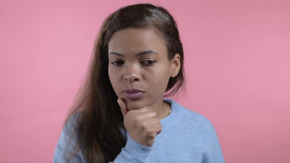 Thinking Mixed Race Woman Looking Up and Around on Pink Studio Background