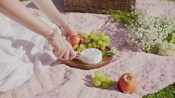 Woman Slicing Camembert Cheese on Wooden Board Gourmet Appetizer or Snack Food alt