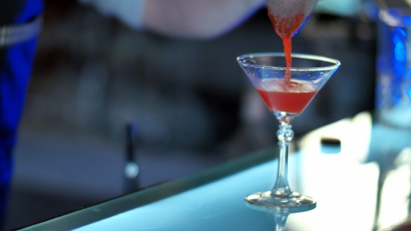 Bartender Pouring Mixed Liqueur Into Prepared Glass Through
