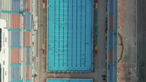 Overhead Birds Eye Top Down Aerial View of Swimmers Training Doing Lanes in Blue Pool alt