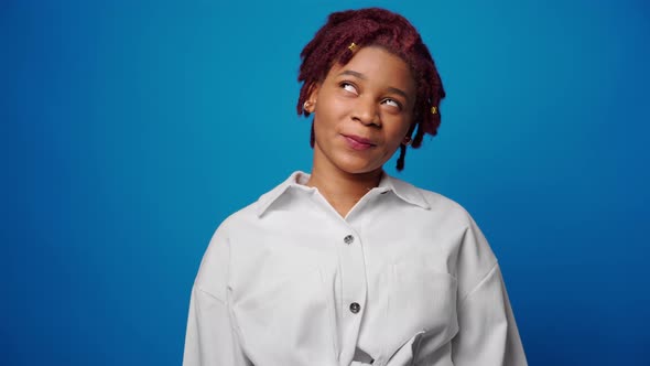 Pensive Young Afro Woman Thinking About Something Against Blue Background