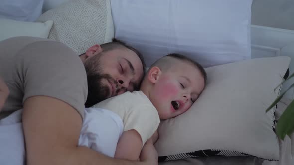 father sleep with his little boy son