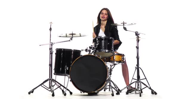 Drummer Girl Starts Playing Energetic Music, She Smiles. White Background. Slow Motion alt