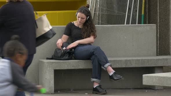 Girl sitting on a stone bench alt