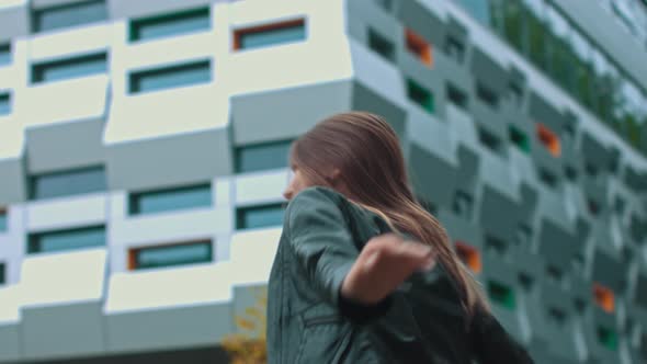 Successful Young Girl Jumps for Joy on the Background of the Office alt