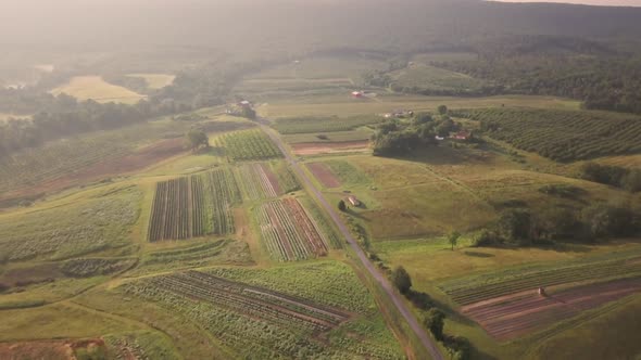 Aerial morning view of farmland in rolling hills and mountains of West Virginia. alt