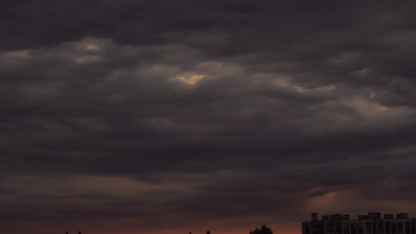 Timelapse of dark clouds floating over city
