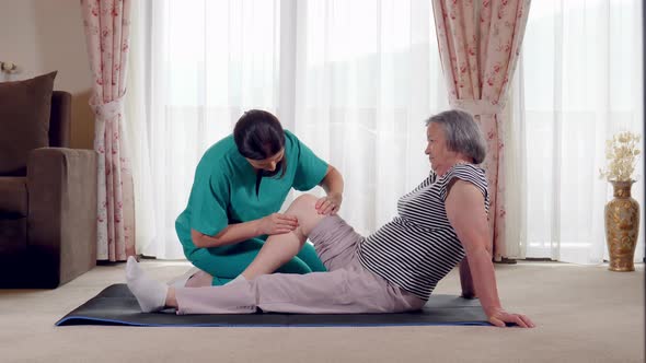 Nurse Giving Leg Massage to Senior Woman in a Retirement Home