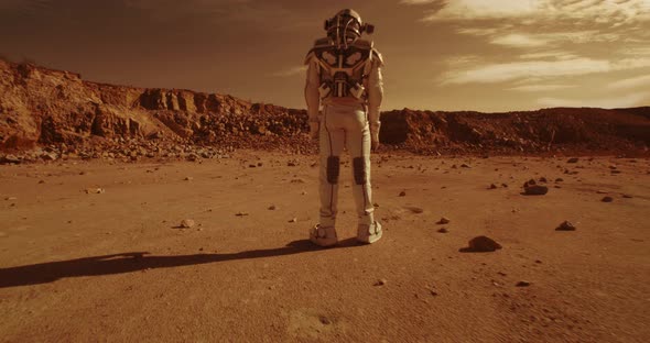 Anonymous Astronauts Standing on Arid Terrain of Mars alt