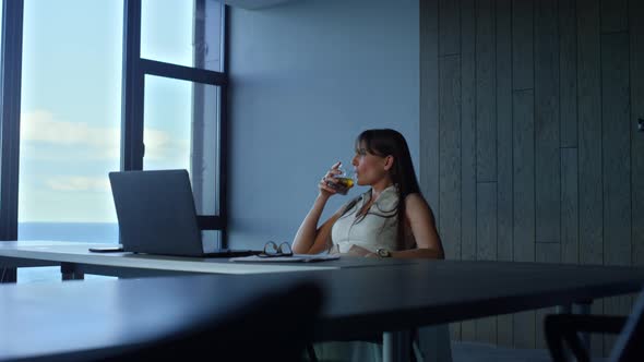Manager Holding Whiskey Glass Resting in Office alt