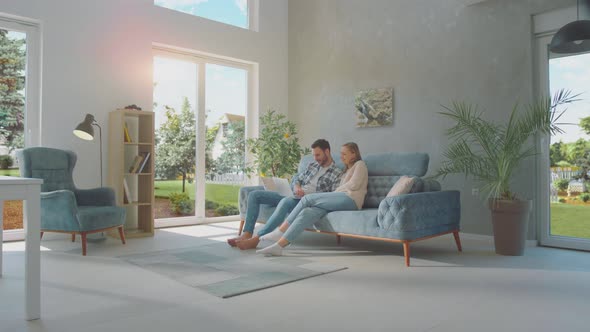 Cheerful couple using laptop alt