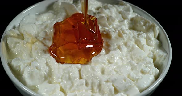 Honey that falls on White Cheese, slow motion 4K alt