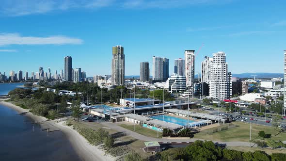 Creative drone view of a inner city Aquatic Centre on a coastal strip with a towering skyline backdr alt