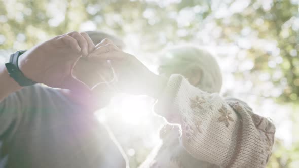 Older Retired Couple Making Heart with Their Hands. Selective Focus alt