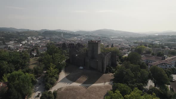 Medieval hilltop Guimarães Castle, city downtown - Aerial orbiting