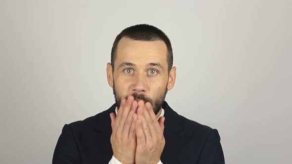 A Young Successful Businessman Smiles and Sends an Air Kiss alt