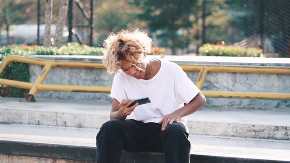 Young Man Using Smartphone At City Parck