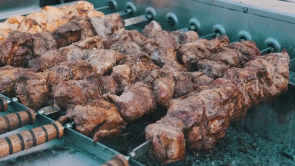Shish Kebab on Skewers Is Cooked on the Automatic Grill at Street Food Festival. alt