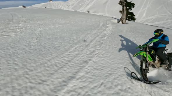 Fpv Drone Chase Man Riding on Snow Bike at Winter Mountain Summit Enjoy Outdoor Extreme alt
