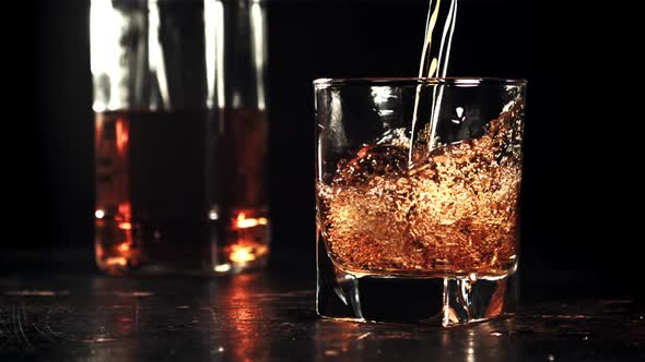 Cognac is Poured Into the Glass with a Whirlpool alt