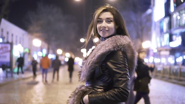 Young Beautiful Pretty Woman Smiling and Posing at City Street in the Night Against Evening Lights alt