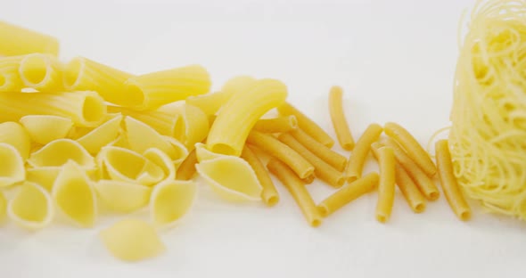 Close-up of various qnd coloured pasta classified by category on white background alt