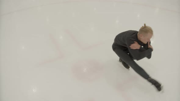 The Skater Is Spinning Sitting on One Leg on the Ice
