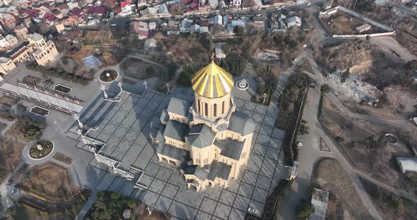 Aerial view of Holy Trinity Cathedral Sameba in Tbilisi Georgia. Sunrise drone footage. alt