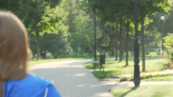 Beautiful Happy Sportswoman Smiling To the Camera While Running in the Park