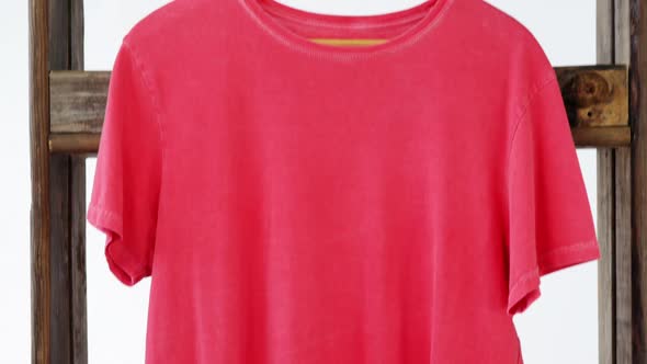 T-shirt hanging on a wooden frame alt