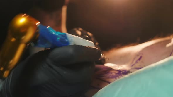 Closeup Shot of Tattooist Filling with Ink Dye Paint Pattern on Client Shoulder