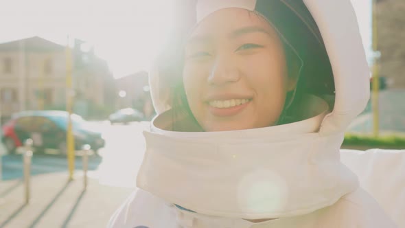 Female astronaut standing in the sun on busy street