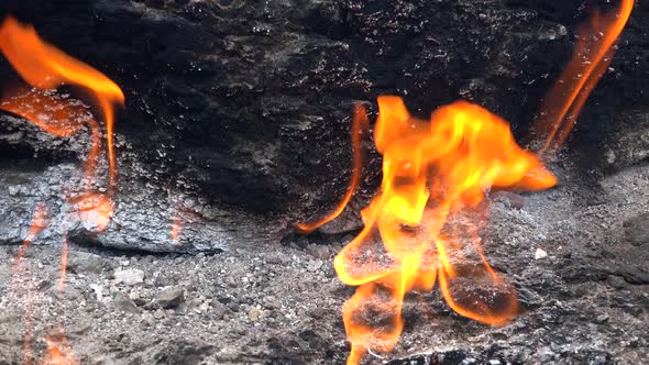 Flame of Methane Underground Emerges From Crack Between Rocks and Burns to Earth alt