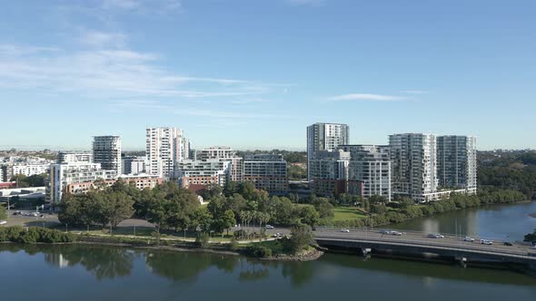 Aerial reveals shot of high rise waterfront apartment complexes on a sunny day alt