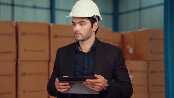 Factory Manager Using Tablet Computer in Warehouse or Factory alt