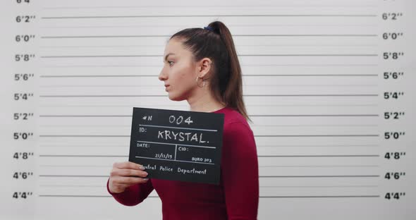 Mugshot of Millennial Woman with Ponytail Turning to Sides While Posing for Photo alt