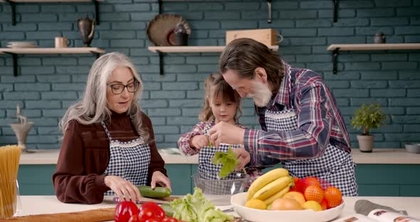 Senior Grandparents Couple with Granddaughter Cooking in Kitchen alt