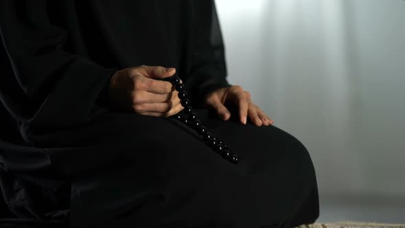 Arab Female Sitting on Prayer Mat, Counting Islamic Beads, Asking Forgiveness alt