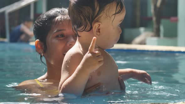 Mother and Child Swim in a Pool with Clean Clear Water