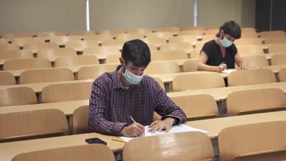College students wearing face masks attend lecture at University and take exam alt