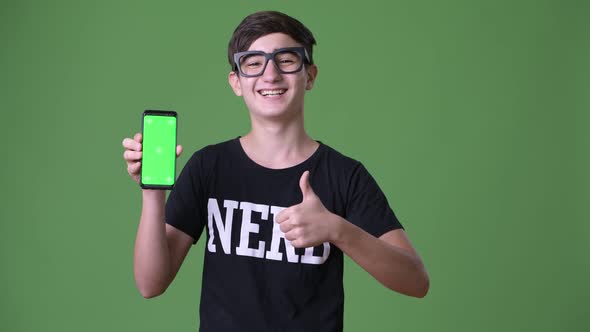 Young Handsome Iranian Teenage Boy Against Green Background alt