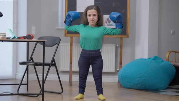 Smiling Caucasian Female Little Person Bumping Boxing Gloves Gesturing Strength Looking at Camera alt