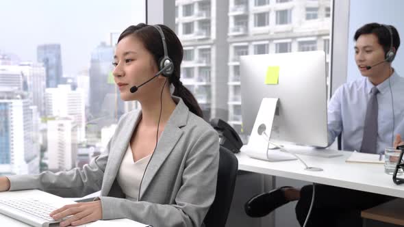 Smiling Asian woman working and Chinese man work in Call Center