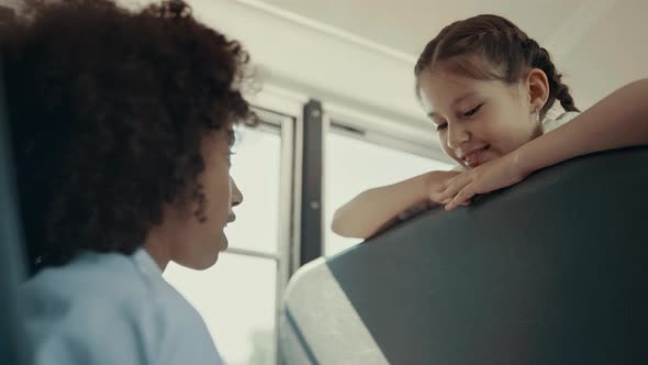 African American Girl Talking with Classmate in Bus alt