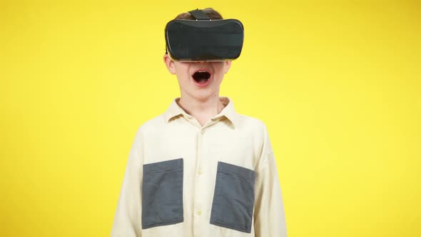 Caucasian Boy in VR Headset Screaming at Yellow Background alt
